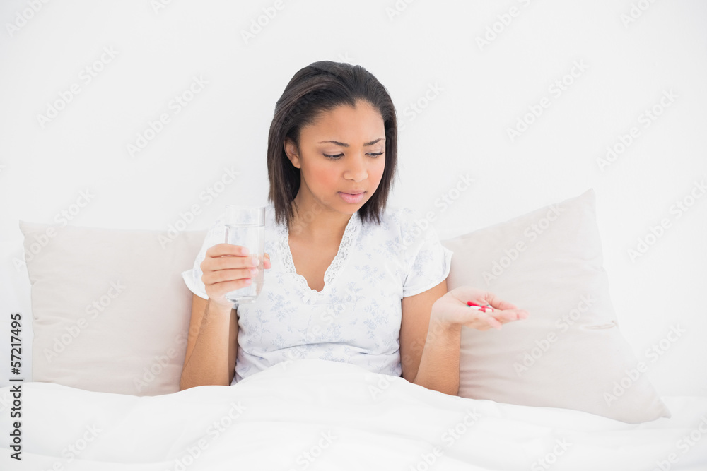 Worried young dark haired model taking medication Worried young dark haired model taking medication
