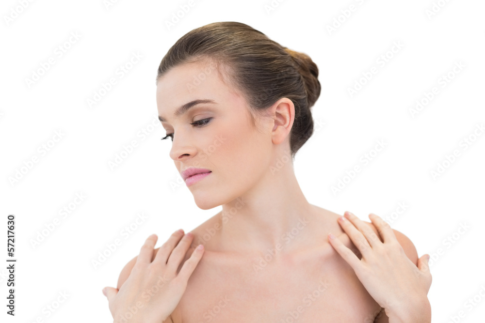 Calm natural brown haired model touching her shoulders Calm natural brown haired model touching her shoulders