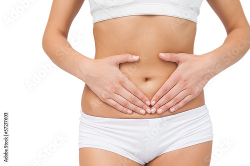 Mid section of slim woman touching her belly with her hands