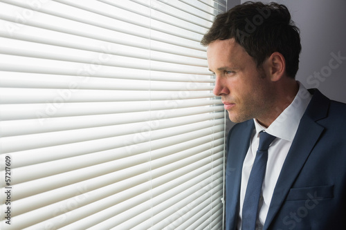 Serious handsome businessman looking out of window