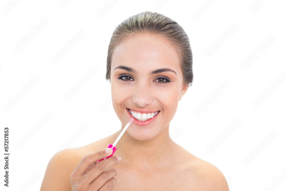 Cheerful brunette woman applying lip gloss Cheerful brunette woman applying lip gloss