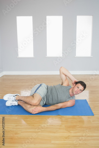Attractive sporty man doing abdominal crunch looking at camera © WavebreakmediaMicro