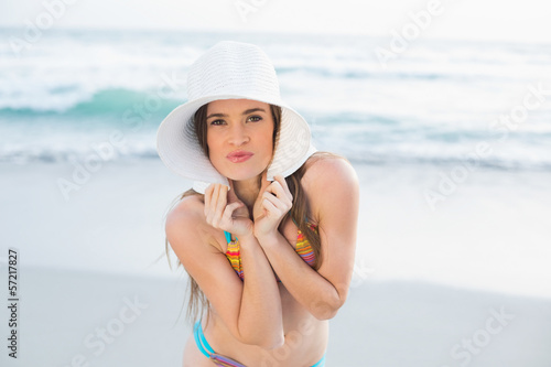 Seductive slim brown haired model in coloured bikini wearing a w