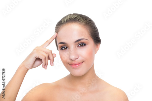 Smiling young brunette woman touching her forehead