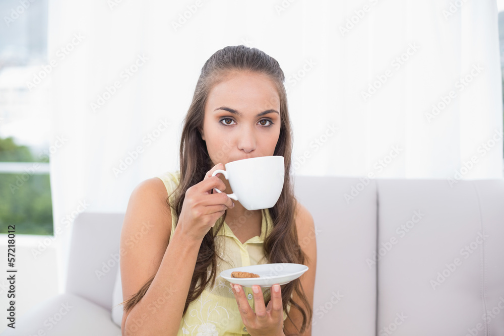 Serious young brunette drinking from a cup Serious young brunette drinking from a cup
