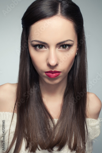 Portrait of angry beautiful long-haired brunette posing