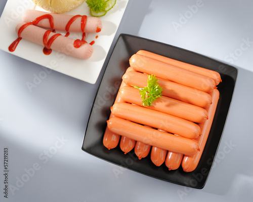 Many wiener sausages on a plate.
