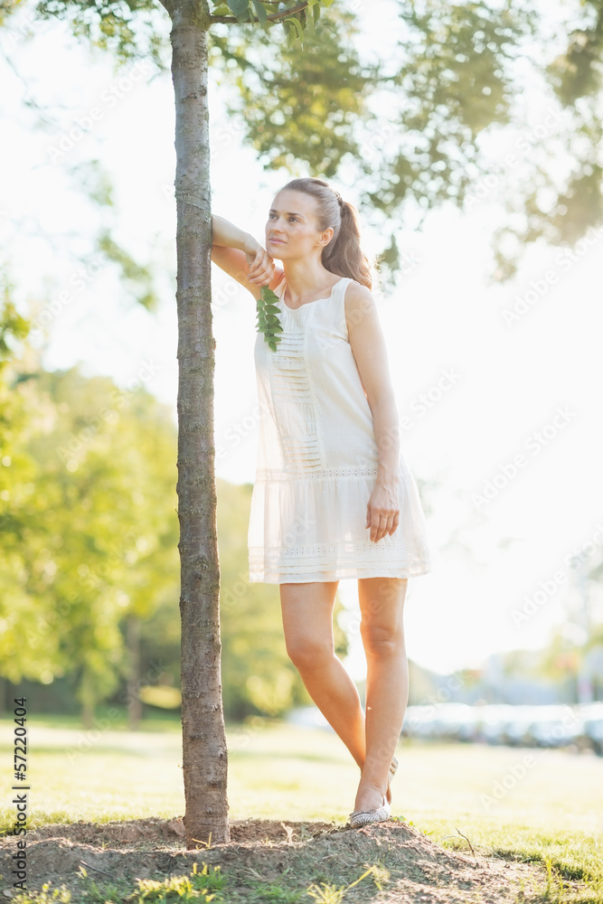 Portrait of thoughtful young woman standing near seedling tree Portrait of thoughtful young woman standing near seedling tree