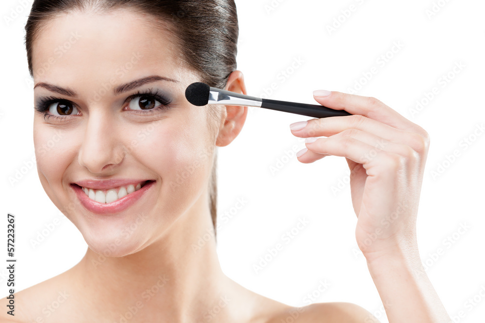 Woman applying make-up with cosmetic brush Woman applying make-up with cosmetic brush