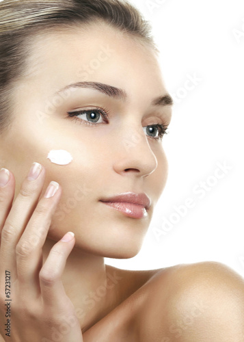 Portrait of young beautiful woman with cream