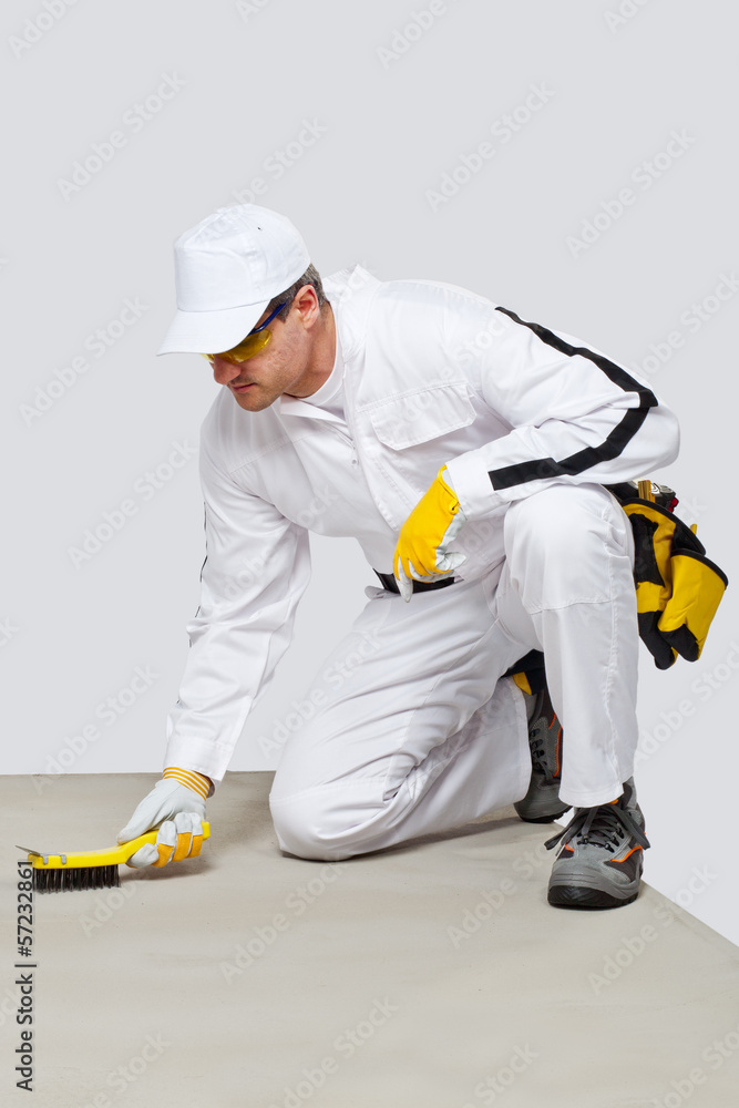 Fototapeta premium Worker with wire brush cleans the cement substrate