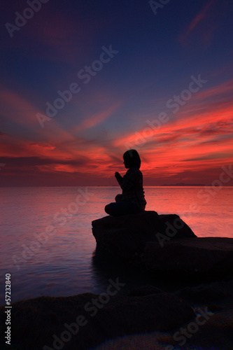 Silhouette yoga girl by the beach sunset