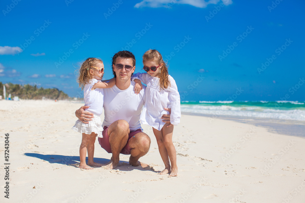 Young happy father and little daughters having fun on white