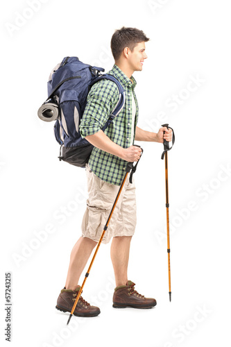 Full length portrait of a hiker with backpack and hiking poles w