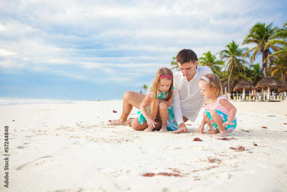 Young Happy father and his adorable little daughters playing on