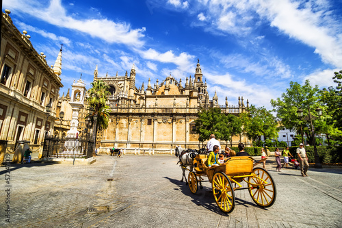 Carriage near Cathedral with Giralda tower, Seville, Spain.