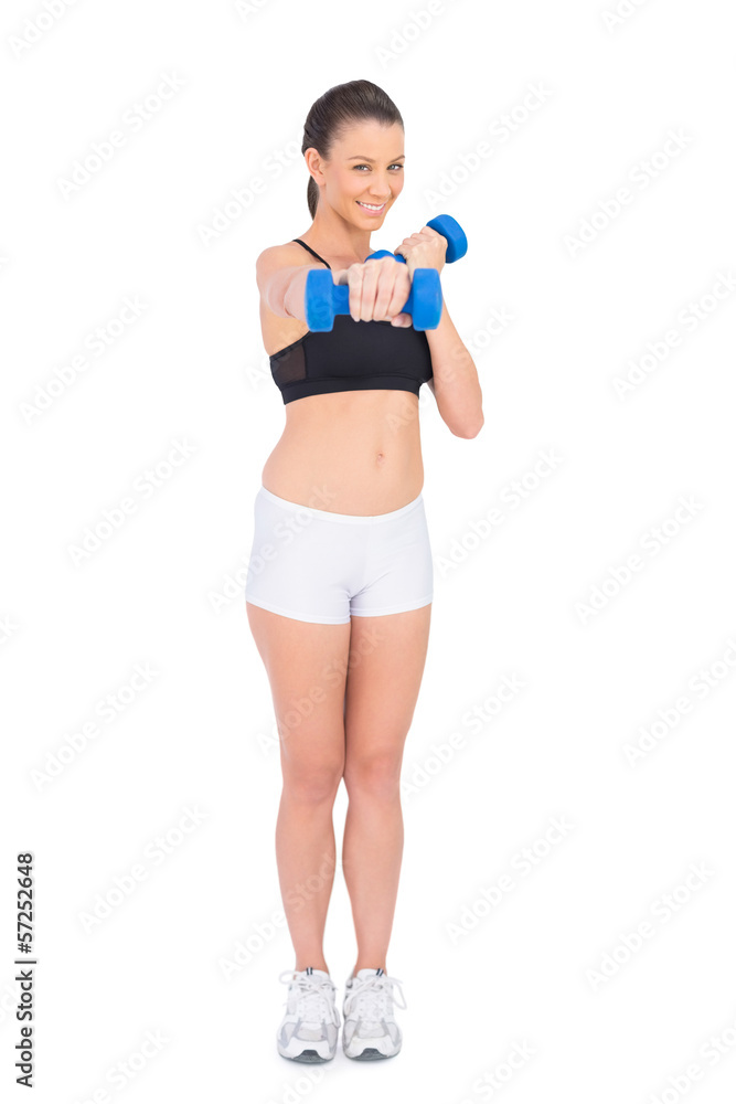 Cheerful fit woman working out with dumbbells Cheerful fit woman working out with dumbbells