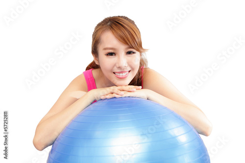 Woman smiling leaning on pilates ball