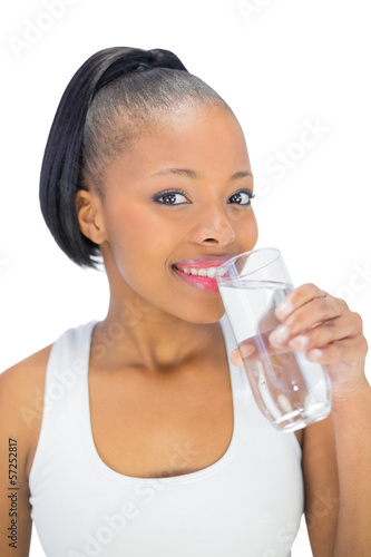 Smiling woman in sportswear drinking water