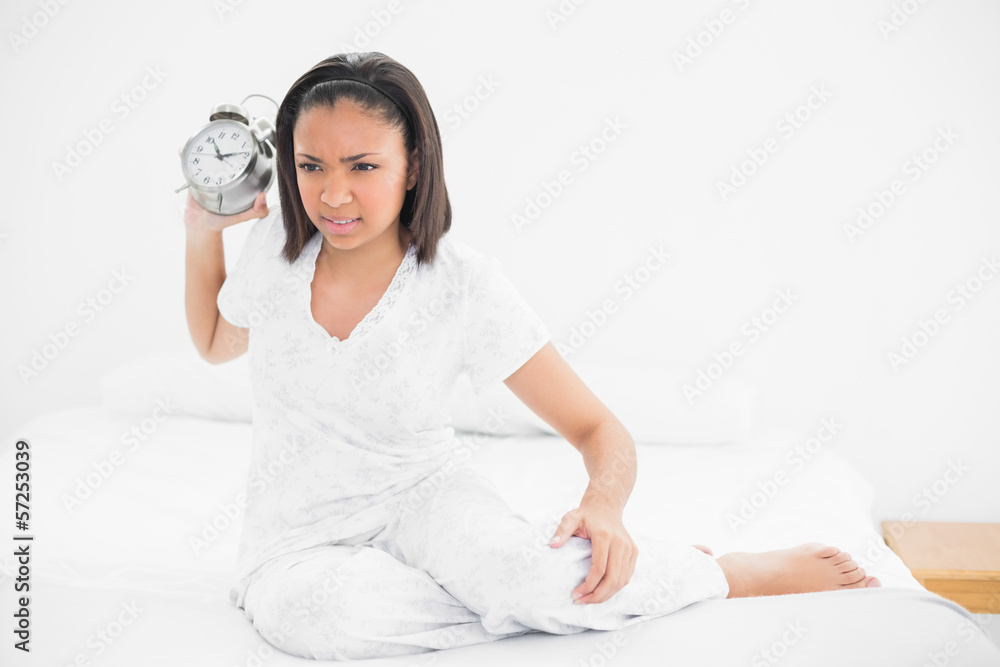 Angry young dark haired model throwing an alarm clock Angry young dark haired model throwing an alarm clock