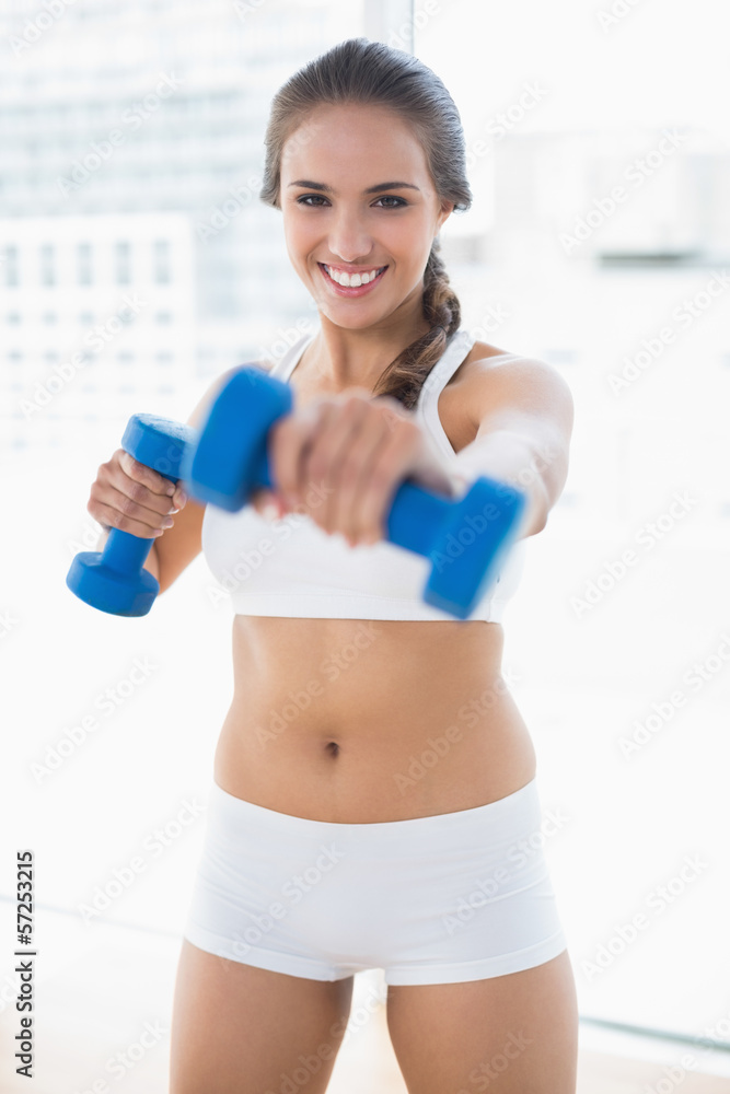 Happy sporty brunette using dumbbells Happy sporty brunette using dumbbells