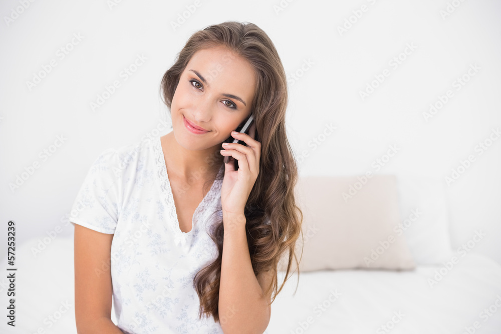 Smiling pretty brunette holding mobile phone Smiling pretty brunette holding mobile phone