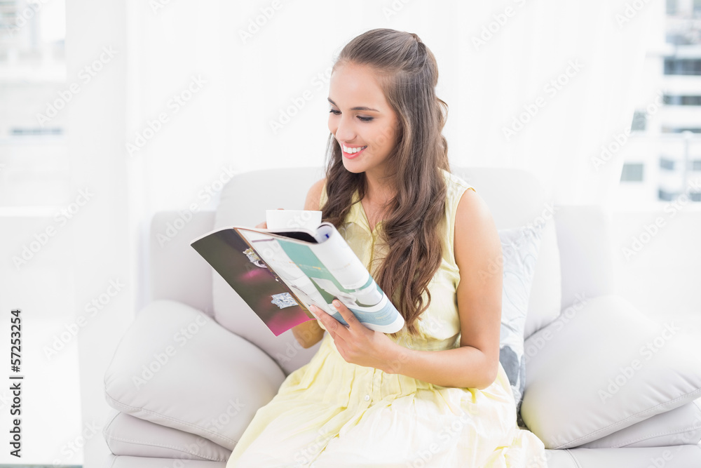 Smiling attractive brunette reading a magazine Smiling attractive brunette reading a magazine