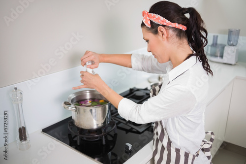 Tableau sur toile Focused gorgeous cook putting salt on vegetables