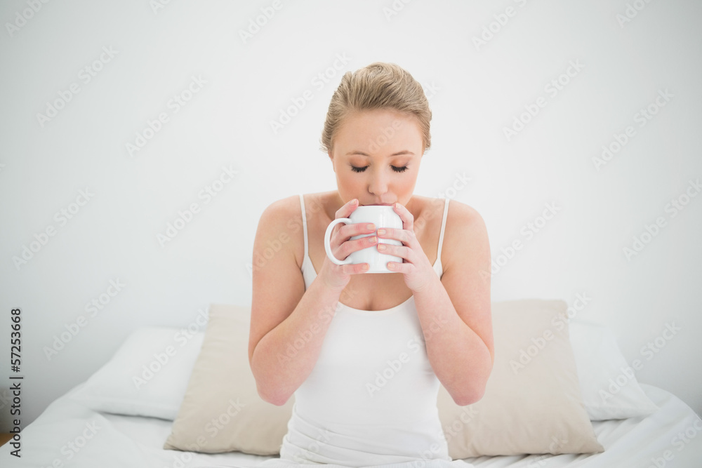 Natural content blonde drinking from a mug Natural content blonde drinking from a mug