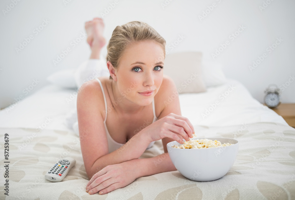 Natural content blonde lying on bed and eating popcorn Natural content blonde lying on bed and eating popcorn