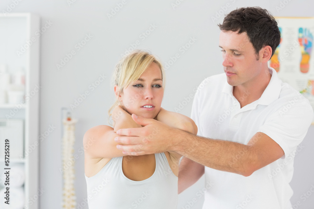 Handsome physiotherapist examining patients back Handsome physiotherapist examining patients back