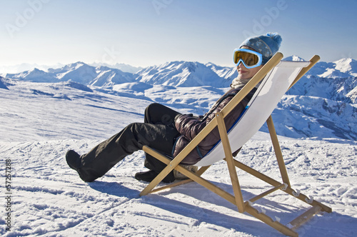 Jeune femme dans une chaise longue au ski