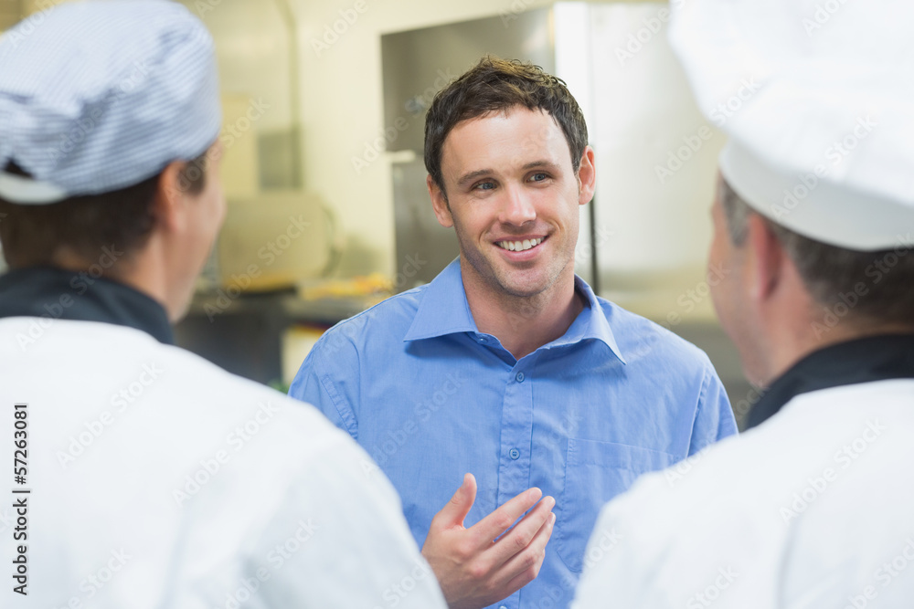 Obraz premium Young smiling manager talking to the staff