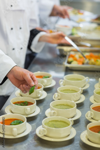 Bowls with soup being garnished