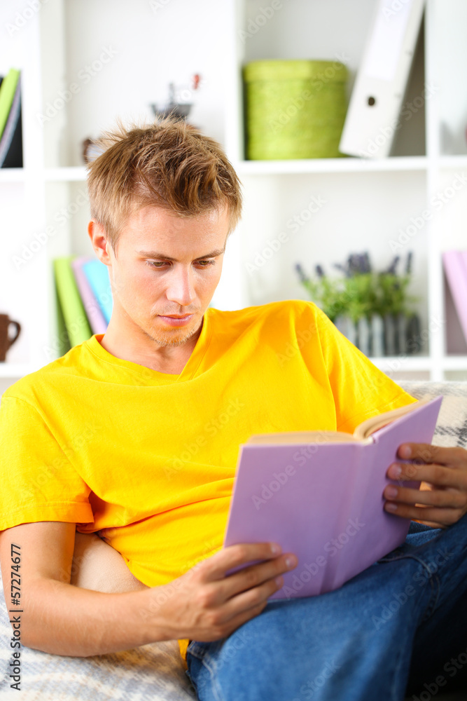 Young man relaxing on sofa with book Young man relaxing on sofa with book