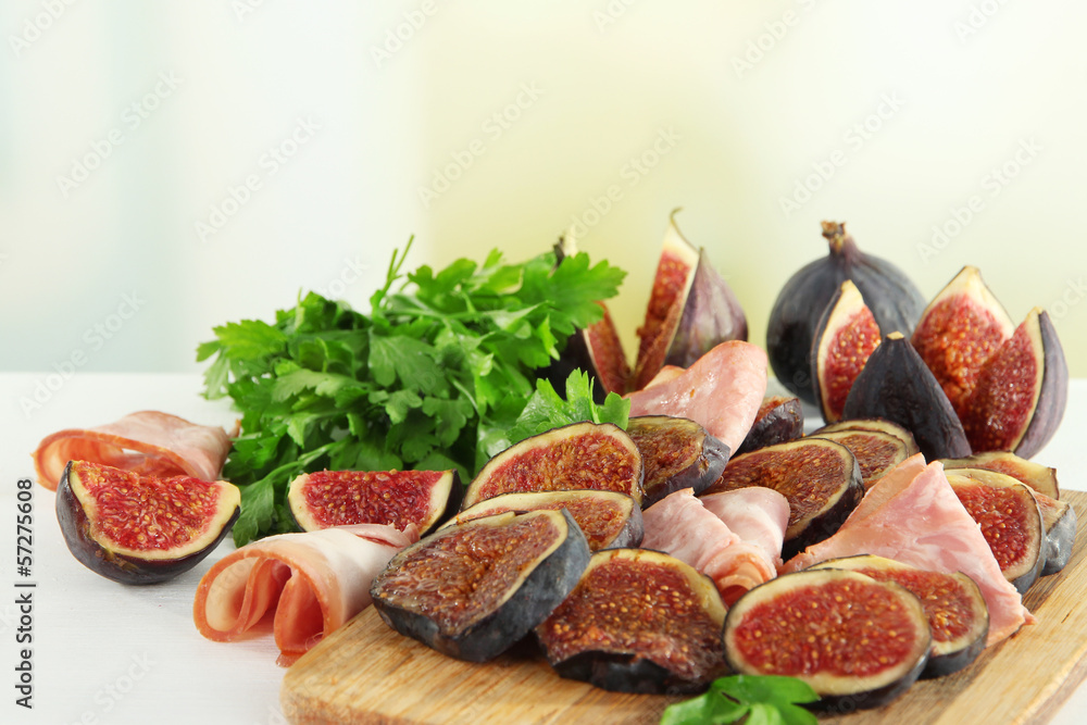 Tasty figs with ham on table
