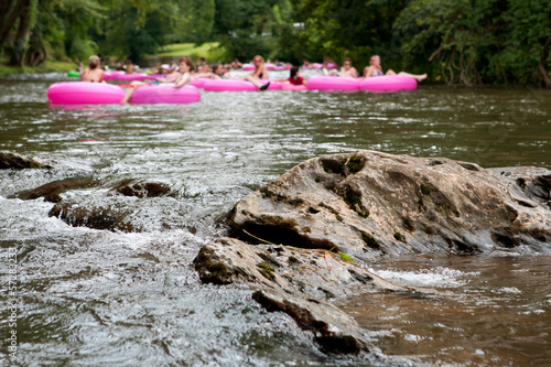 Fényképezés Defocused People Tubing Down River Approach Boulder In Focus