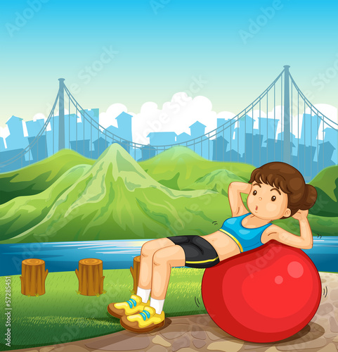 A girl exercising near the river across the tall buildings