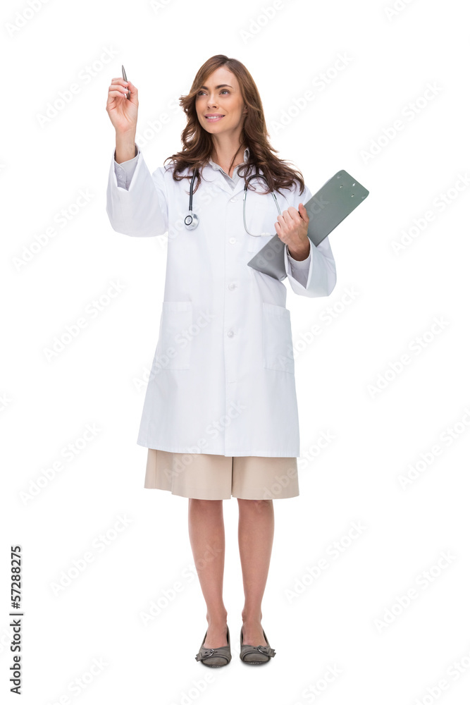 Brunette doctor holding clipboard and pointing at something Brunette doctor holding clipboard and pointing at something