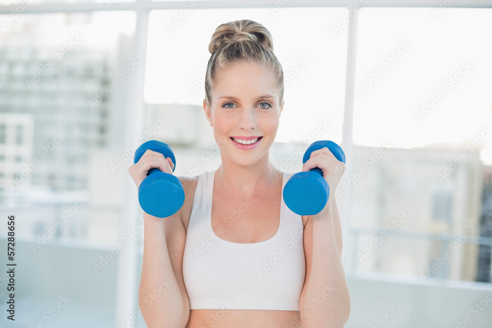 Cheerful sporty blonde working out with dumbbells Cheerful sporty blonde working out with dumbbells