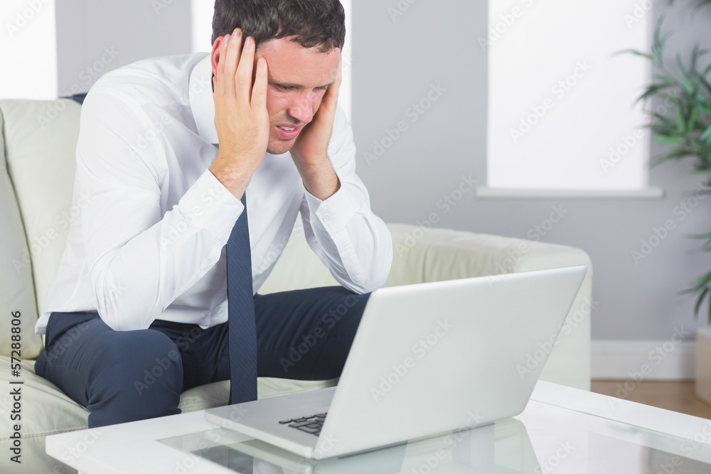 Upset handsome businessman having a headache Upset handsome businessman having a headache