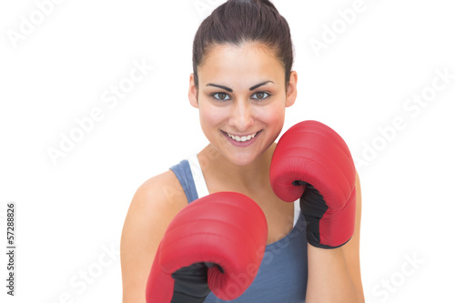 Smiling sporty brunette wearing red boxing gloves photo