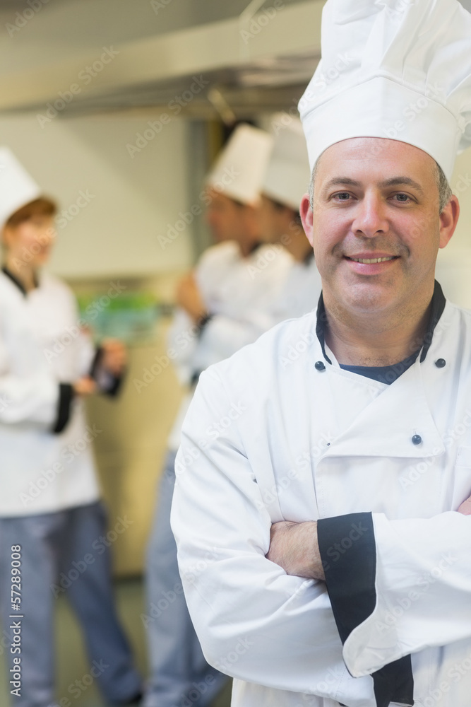 Smiling mature chef posing in a kitchen Smiling mature chef posing in a kitchen