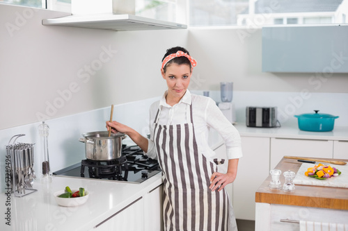 Calm pretty woman with apron cooking