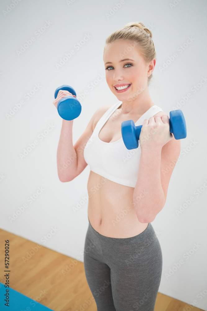 Gleeful sporty blonde holding dumbbells Gleeful sporty blonde holding dumbbells