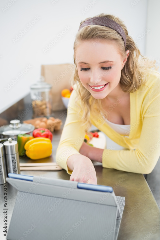 Smiling cute blonde looking at tablet Smiling cute blonde looking at tablet