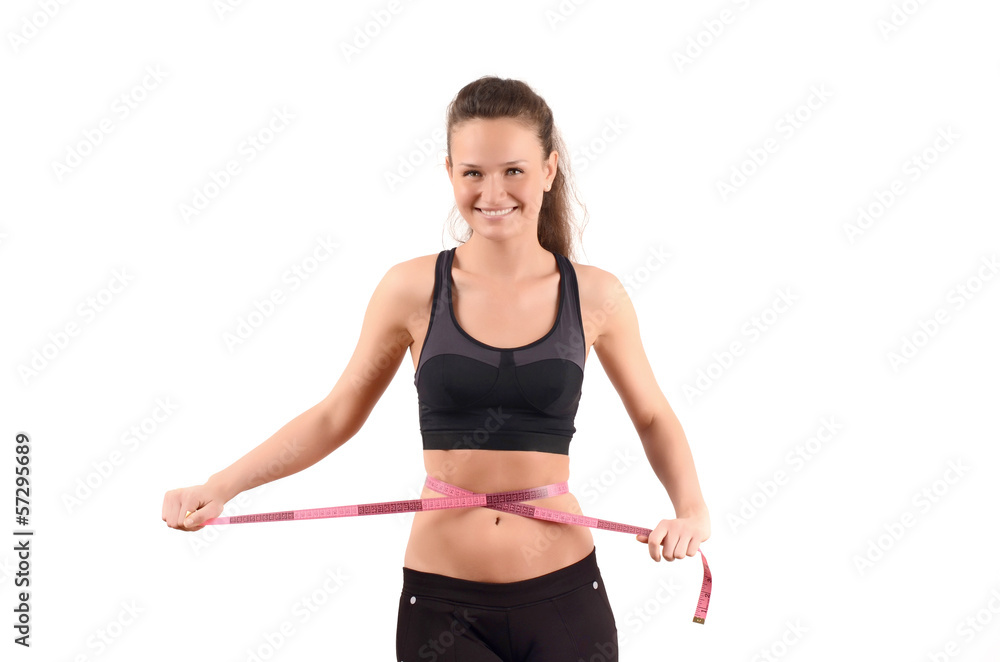 Fit girl measuring her waist with a measuring tape in inch