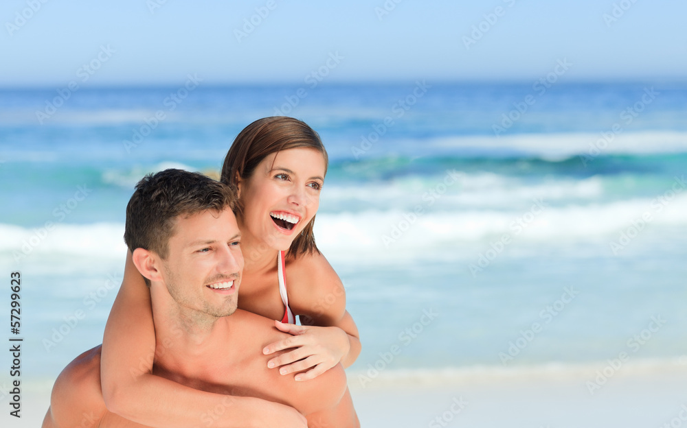 Man having wife a piggyback on the beach Man having wife a piggyback on the beach