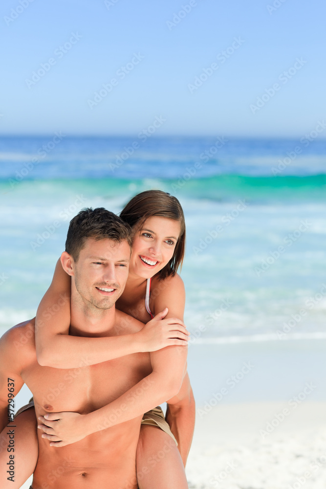 Man having wife a piggyback on the beach Man having wife a piggyback on the beach
