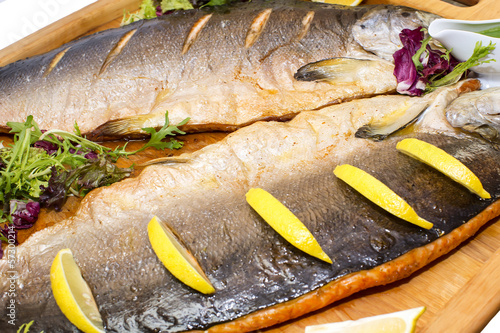 Baked salmon with vegetables on a wooden platter